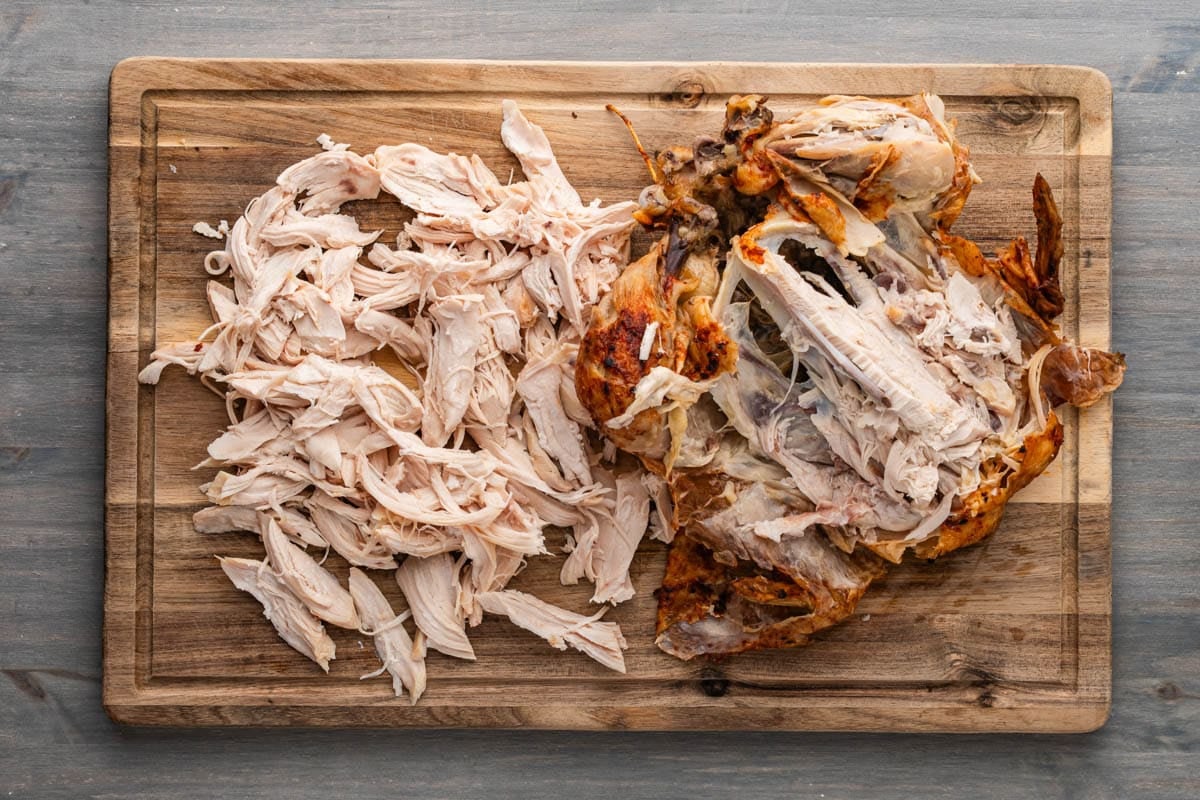 a rotisserie chicken cut apart on a cutting board