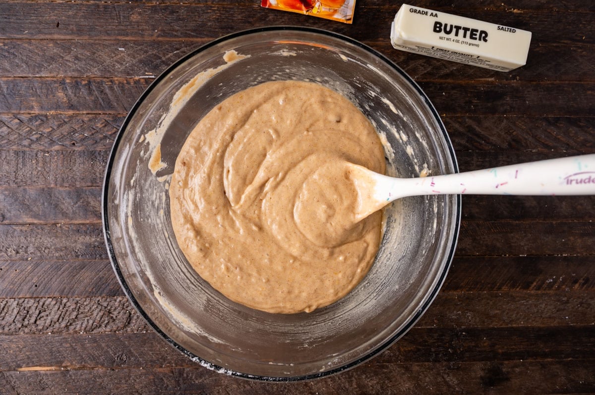 apple cider donut batter in a bowl with a rubber spatula