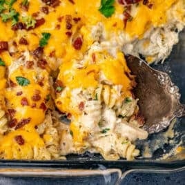 closeup of a spoonful of crack chicken pasta in a glass dish