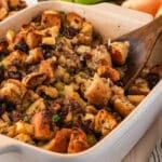 a spoon in a casserole dish of sausage stuffing